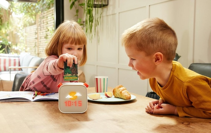 2 enfants mettent la carte d'une histoire dans leur boitier Yoto pour écouter en français ou en anglais leur histoire préférée